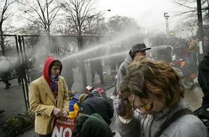 Police officers fire streams of pepper spray into a crowd of protesters.January 20, 2005. Photo by Jim Bourg/Reuters 