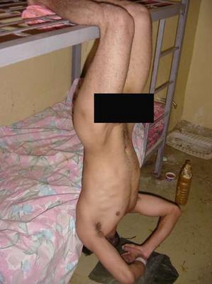 Naked Iraqi prisoner hangs upside down in abu gharib photo taken in Iraq