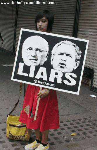 A girl holds up a sign with a picture of bush and cheney that says Liars, which they are 092405